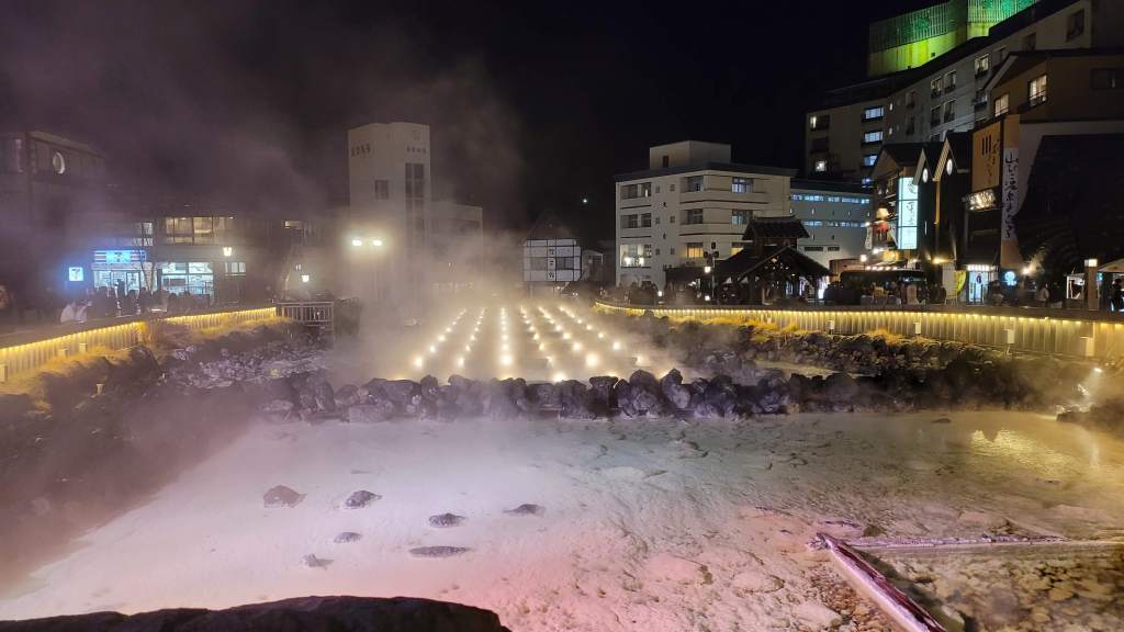 Steam rising from the Yubatake hot-water field at night in Kusatsu Onsen, Gunma, Japan