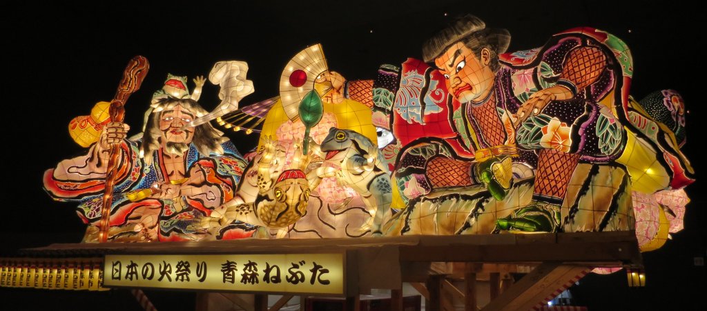 A large painted Nebuta float lit at night in Aomori