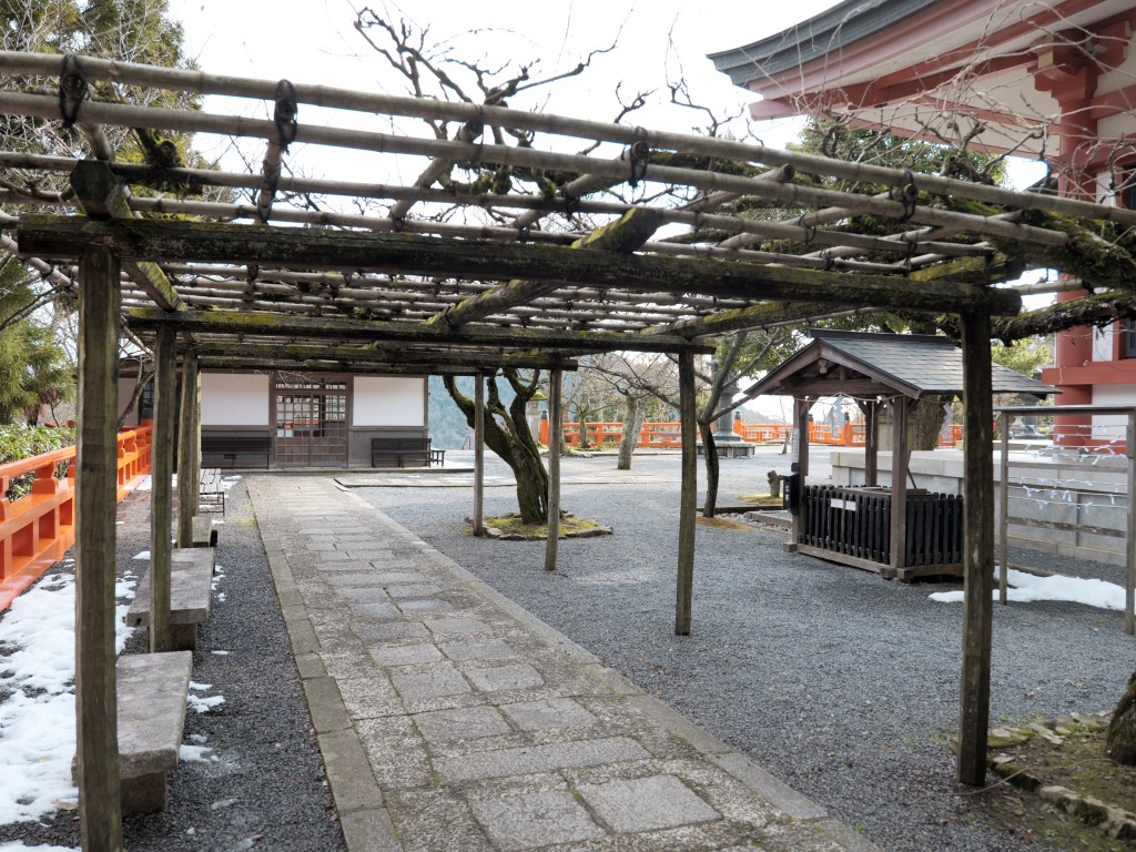 Snow patches and bare trees in the courtyard of Kurama-dera, Kyoto, Japan