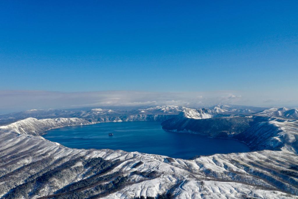 The blue crater lake of Lake Mashu seen from an overlook in eastern Hokkaido, Japan