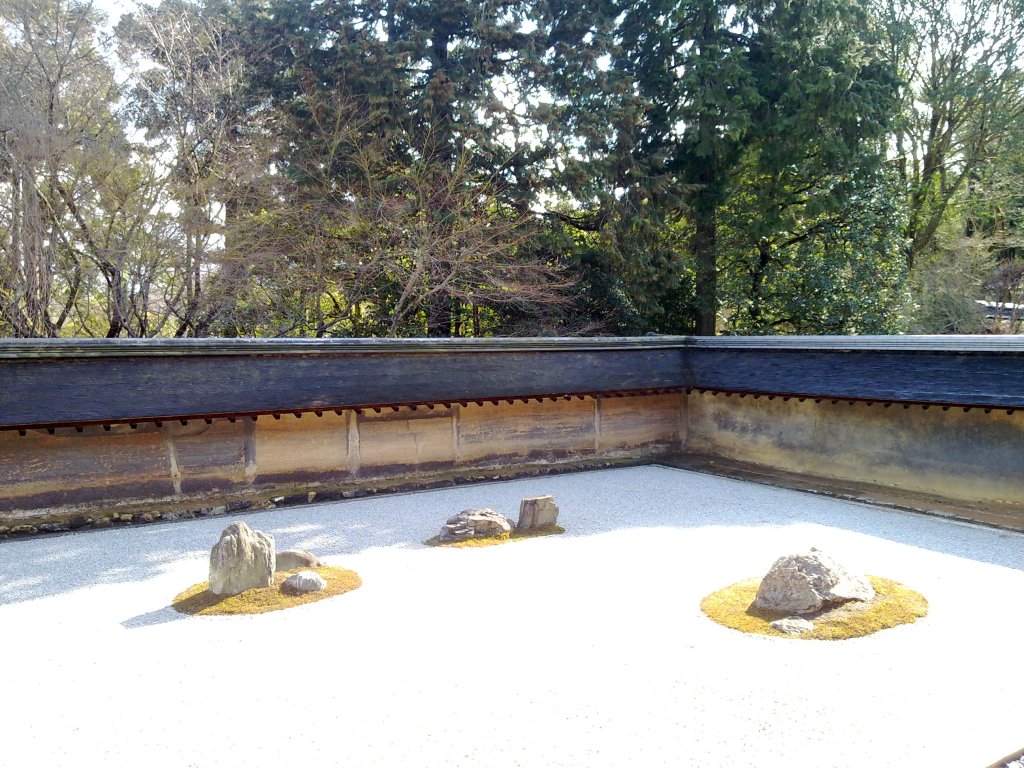 The raked gravel and fifteen rocks of the Ryoan-ji rock garden in Kyoto