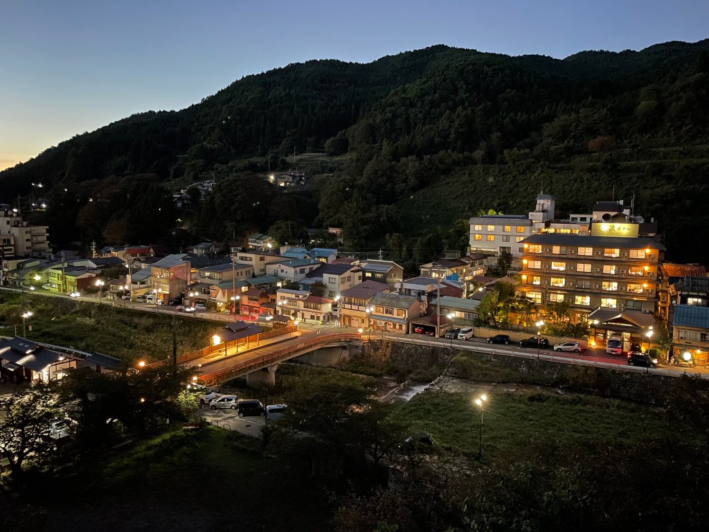 Shibu Onsen street lit at night with steam rising between the buildings