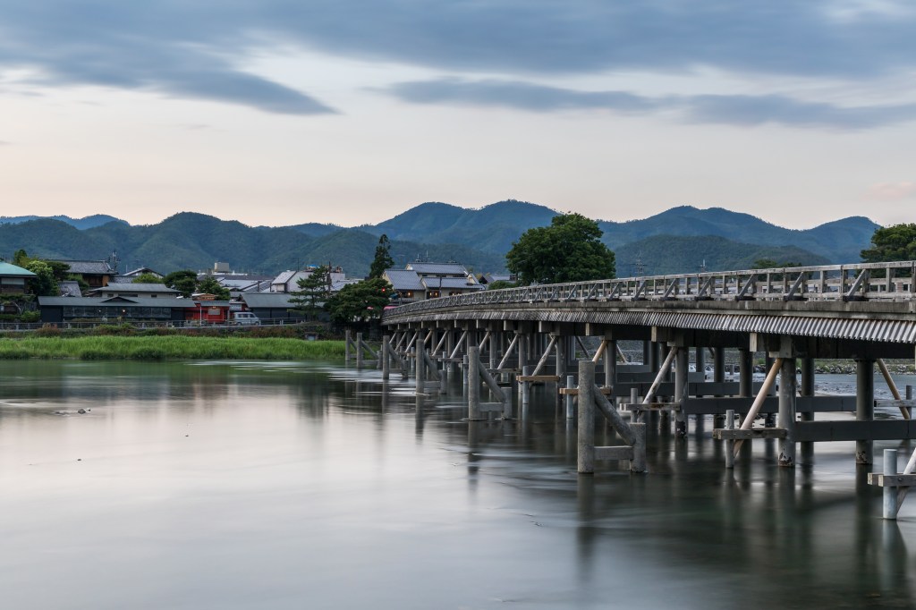 Togetsukyo Bridge over the Katsura River at dusk in Arashiyama, Kyoto, Japan